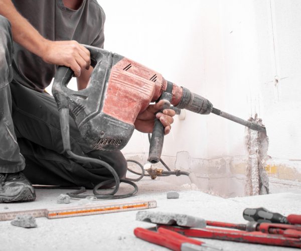 Installer,Stabs,Hole,With,Hilti,Rotary,Hammer,In,The,Wall